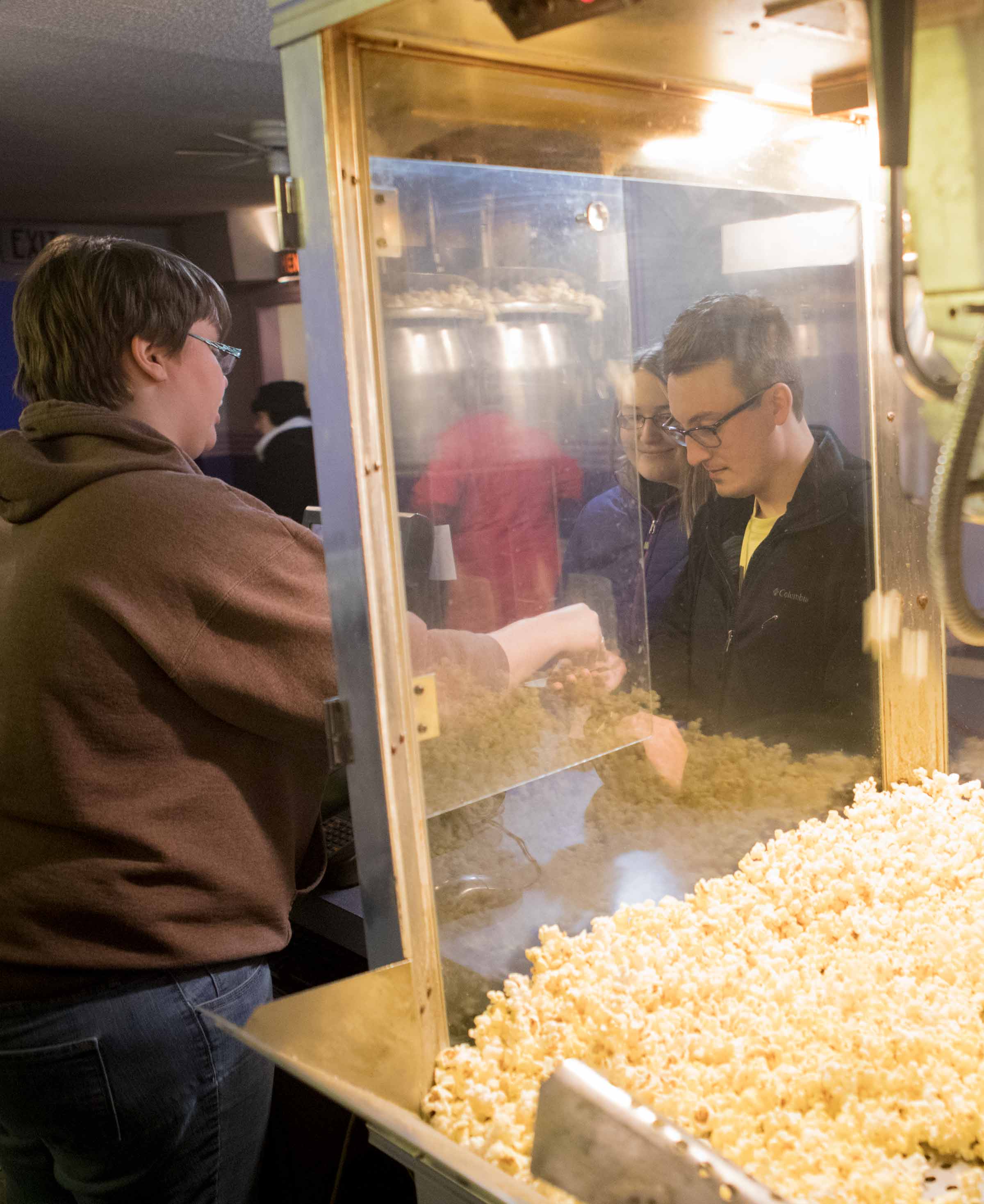 Fifth-year pharmacy student Caitlin Nahirniak and Andy Kremyar, a 2015 Ohio Northern University graduate, buy concessions before the start of a free screening of the movie 鈥淔riday Night Lights鈥� at Ada Theatre.